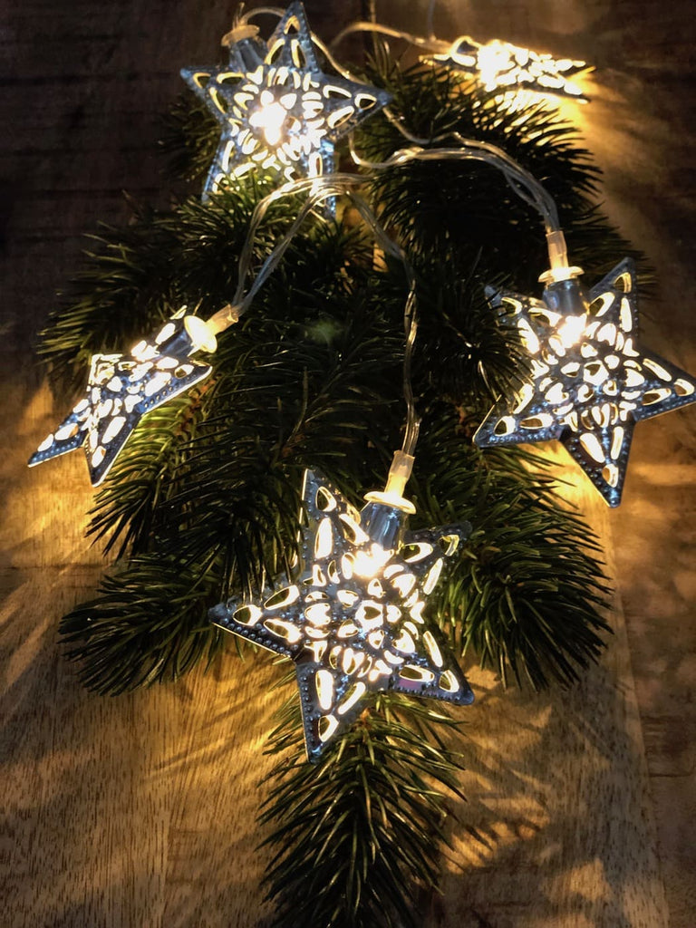Lichterkette mit 10 silbernen Sternen, auf Tannengrün dekoriert