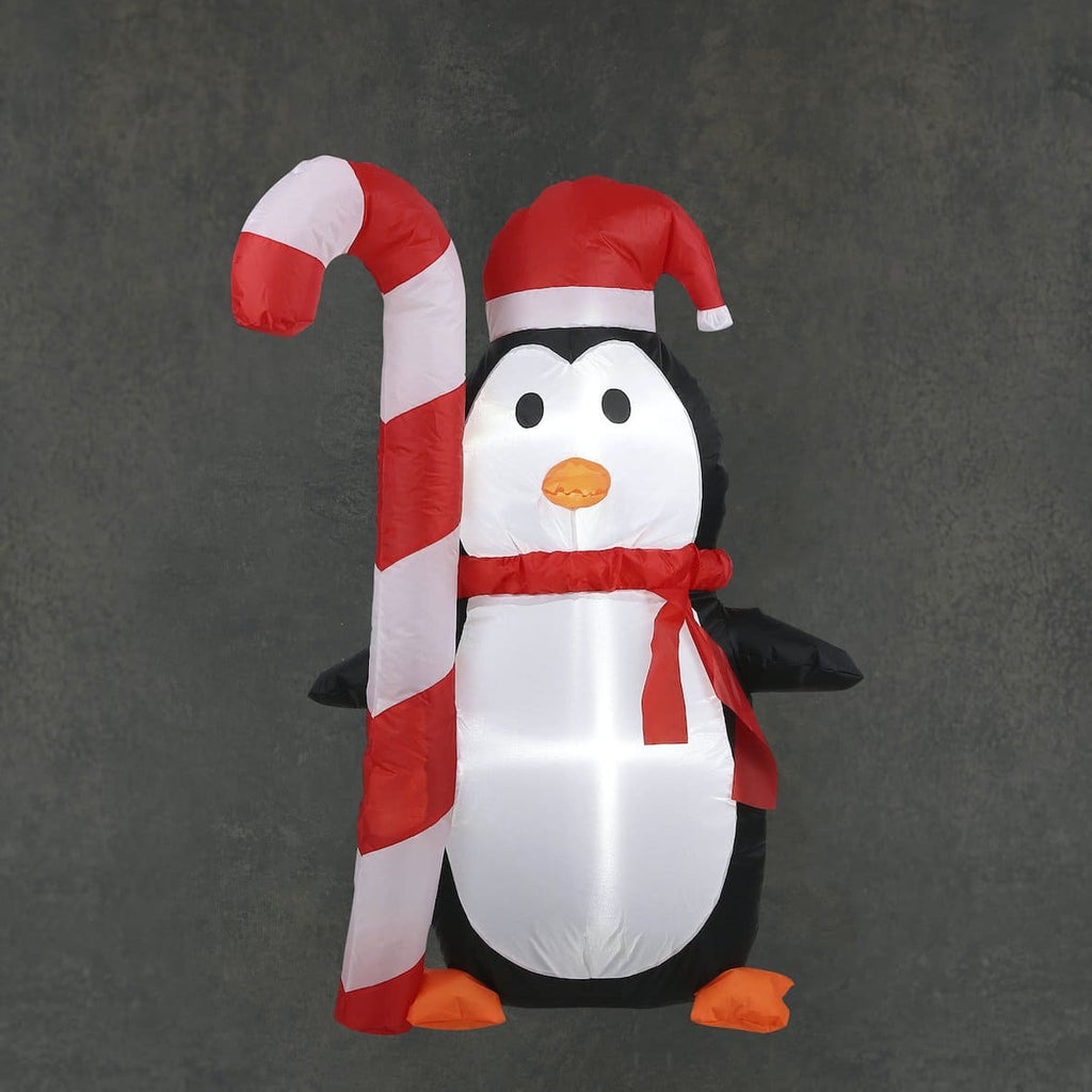 Ein aufblasbarer Pinguin, mit einer Zuckerstange in der Hand, der eine tolle Winterstimmung erzeugt.