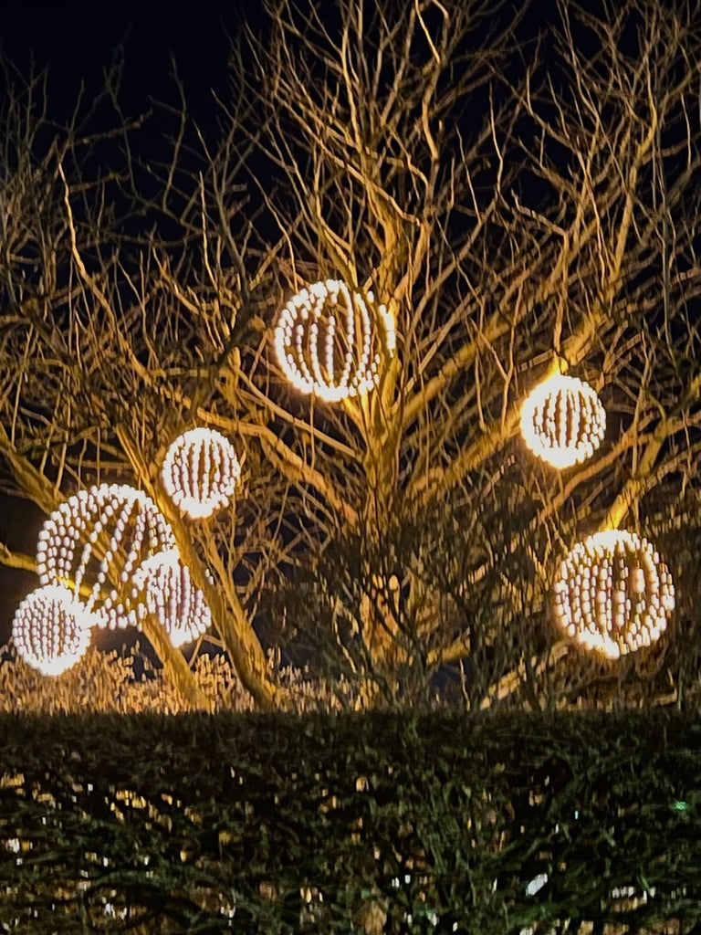 Bild von mehreren 3D Leuchtkugeln, die alle hübsch in einem Baum dekoriert sind. Die 216 Lichter der Kugel sind sehr schön um die Kugel herum gebunden.