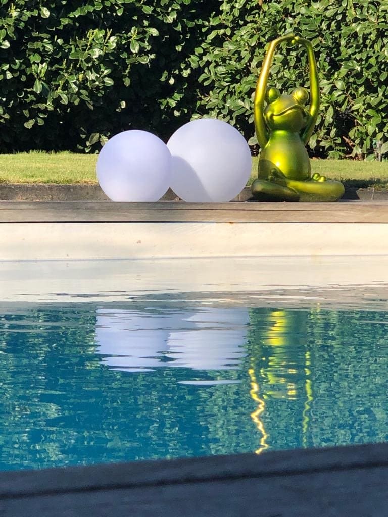Zwei Solarkugeln am Pool mit einem Yoga Frosch.
